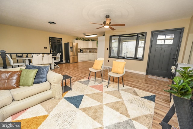 living room with light wood-type flooring and ceiling fan