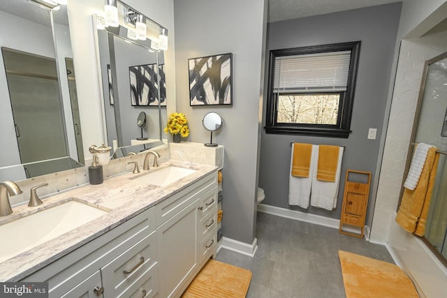 full bathroom featuring vanity, a textured ceiling, toilet, and bath / shower combo with glass door