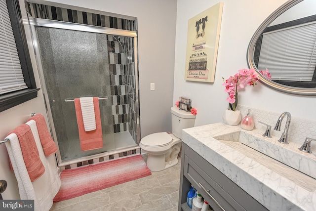 bathroom featuring toilet, tile patterned flooring, vanity, and walk in shower