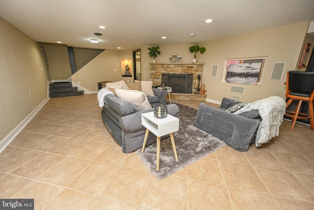 tiled living room with a stone fireplace