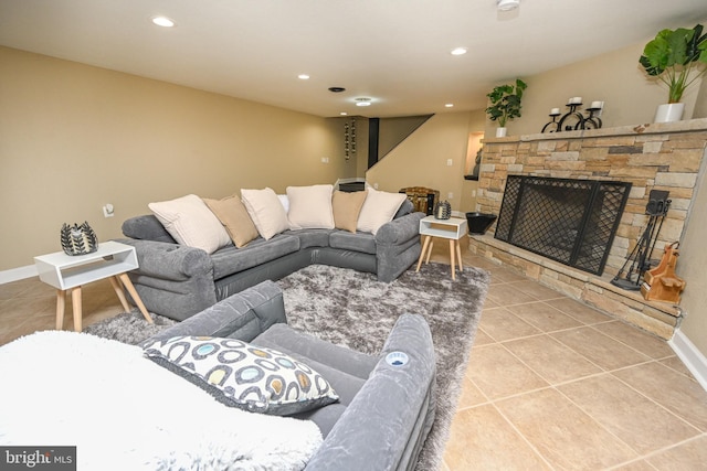 tiled living room with a stone fireplace