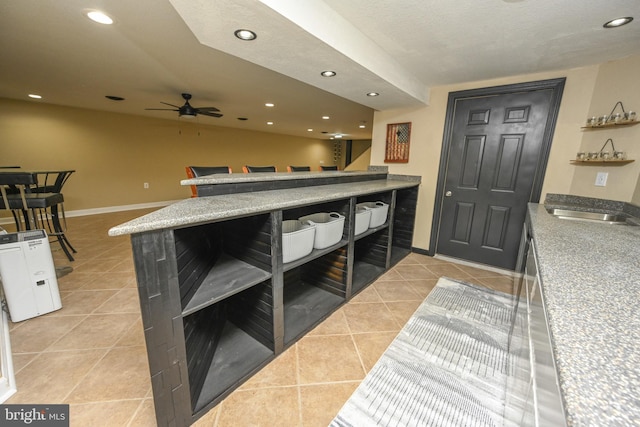 kitchen featuring ceiling fan, sink, light tile patterned floors, and a textured ceiling