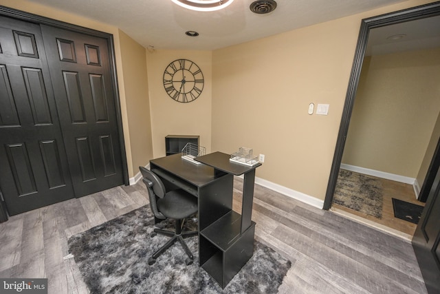 home office with a textured ceiling and hardwood / wood-style flooring