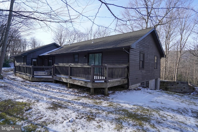 snow covered house featuring a deck