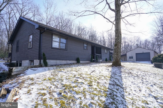 view of front of home featuring a garage and an outbuilding