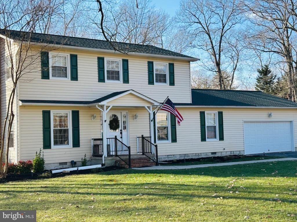 view of front of property with a garage and a front lawn