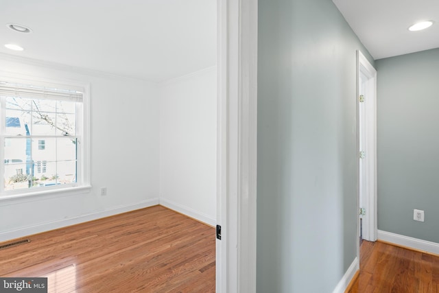 hallway with crown molding and hardwood / wood-style floors