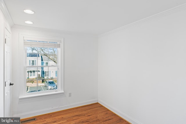 empty room with hardwood / wood-style flooring and ornamental molding