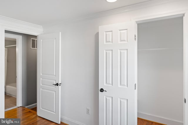 bedroom with hardwood / wood-style floors and ornamental molding