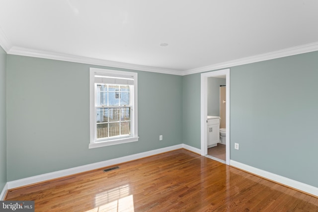 empty room with hardwood / wood-style flooring and ornamental molding