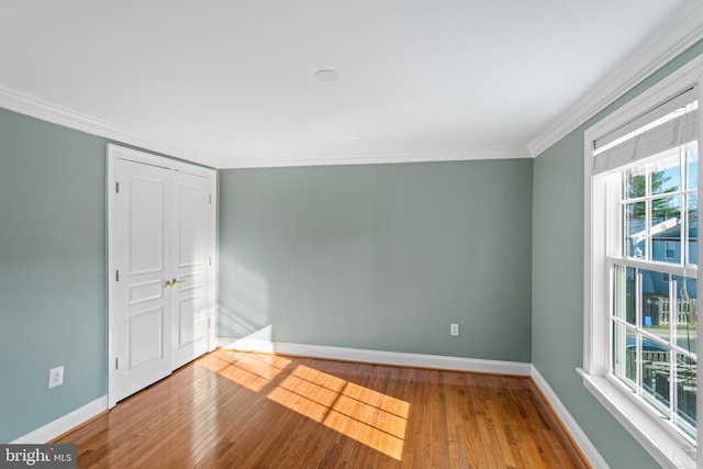 empty room featuring hardwood / wood-style floors and ornamental molding