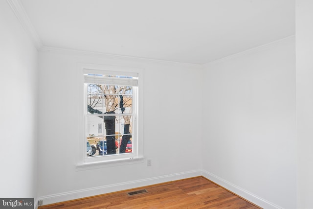 spare room with wood-type flooring and ornamental molding