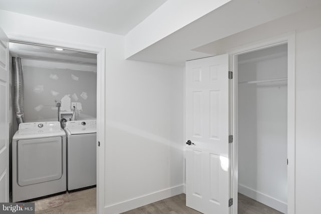 washroom with washer and dryer and light wood-type flooring