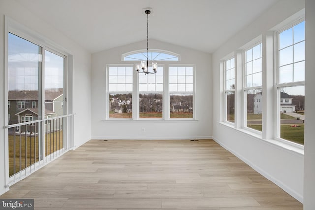 unfurnished sunroom featuring a notable chandelier and vaulted ceiling