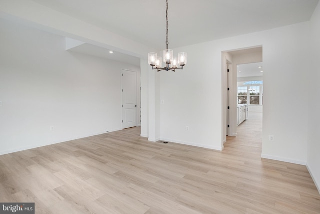 unfurnished dining area featuring an inviting chandelier and light wood-type flooring