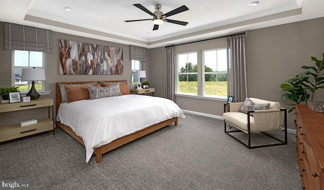 carpeted bedroom with ceiling fan, a raised ceiling, and crown molding