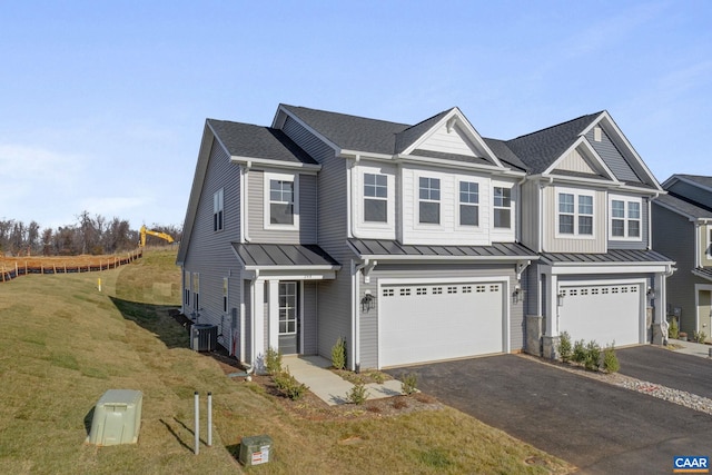 view of front of home with central AC, a garage, and a front lawn