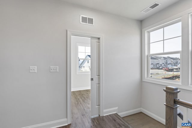 hallway featuring a healthy amount of sunlight and hardwood / wood-style flooring