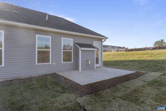 rear view of property featuring a patio area and a lawn