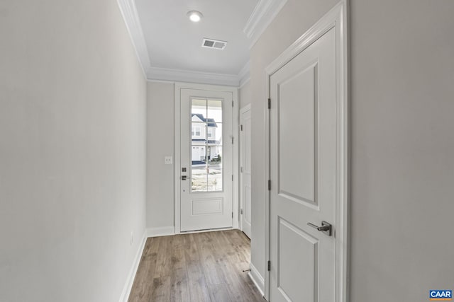 entryway featuring ornamental molding and light hardwood / wood-style flooring