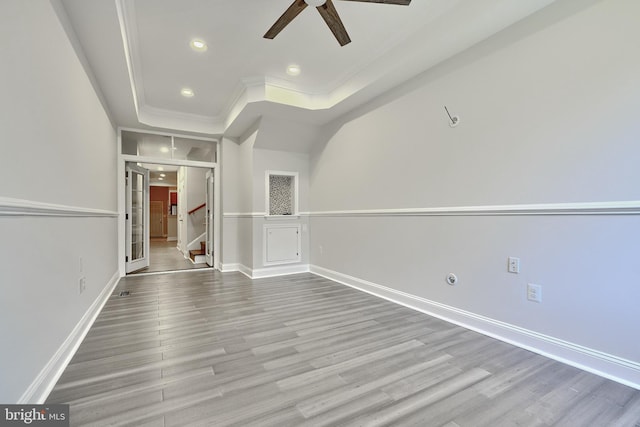 empty room featuring ceiling fan, ornamental molding, french doors, and light hardwood / wood-style flooring