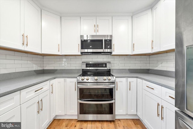 kitchen featuring tasteful backsplash, light hardwood / wood-style flooring, white cabinets, and appliances with stainless steel finishes