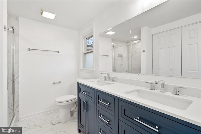 bathroom featuring vanity, a shower with shower door, and toilet