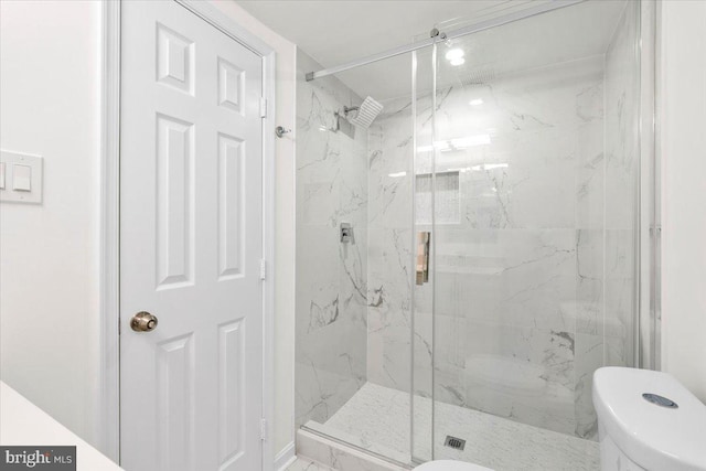 bathroom with toilet and a shower with shower door