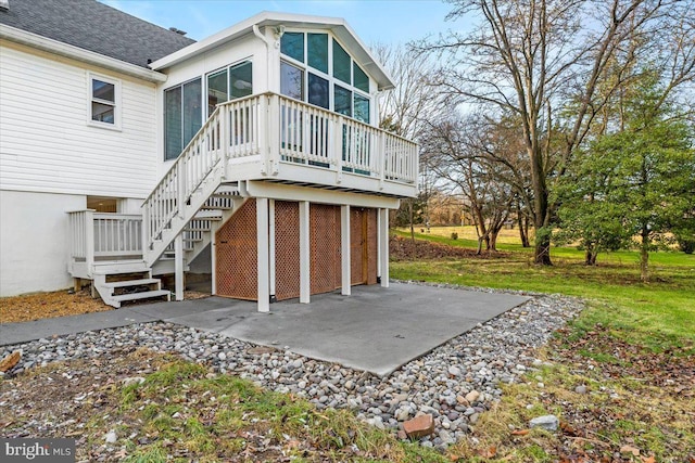 back of property with a sunroom and a patio area