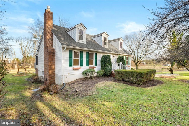 cape cod-style house with a front yard