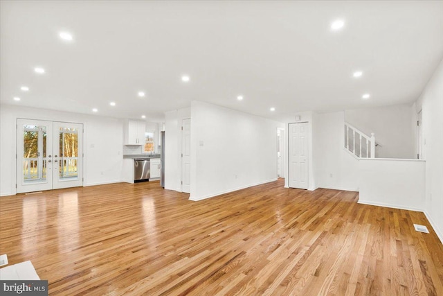 unfurnished living room featuring light hardwood / wood-style flooring and french doors