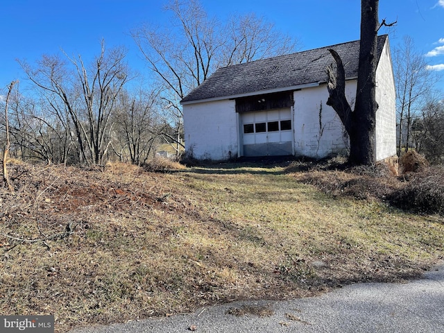 view of property exterior with a garage and an outdoor structure