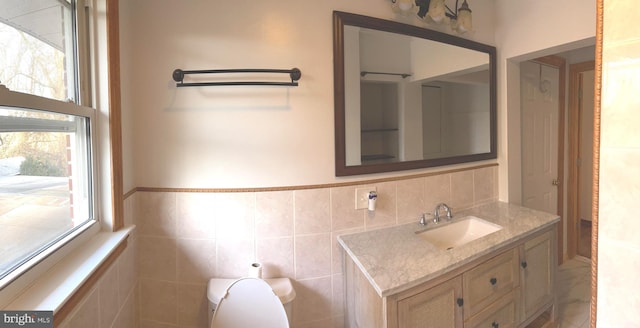 bathroom featuring vanity and tile walls