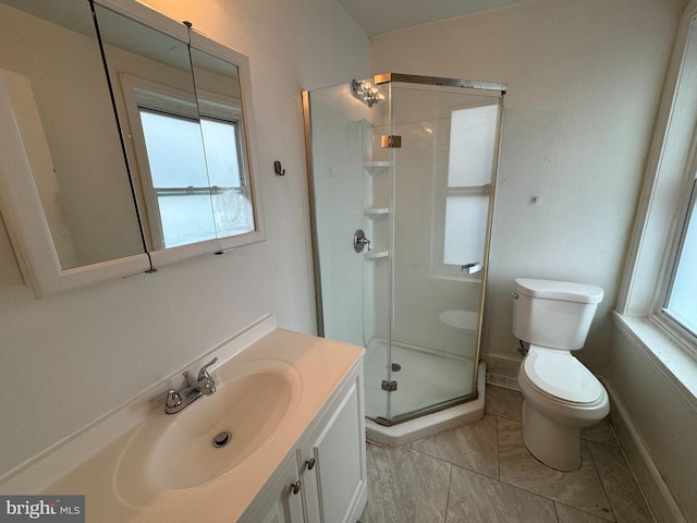 bathroom featuring vanity, toilet, and an enclosed shower