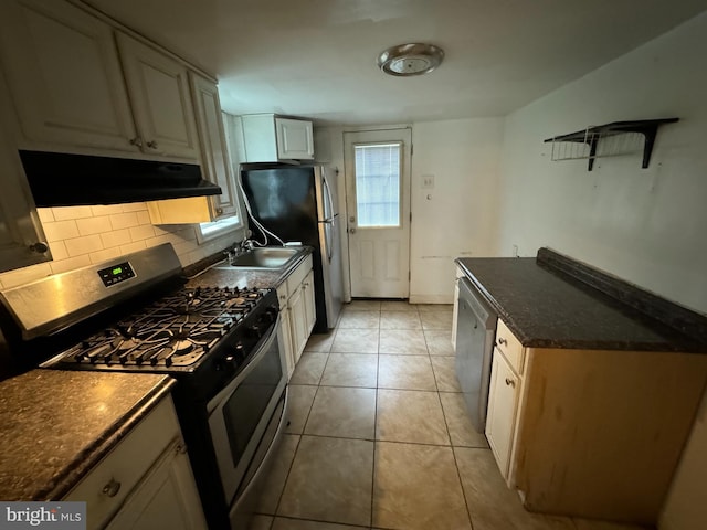 kitchen featuring appliances with stainless steel finishes, tasteful backsplash, light tile patterned floors, and sink