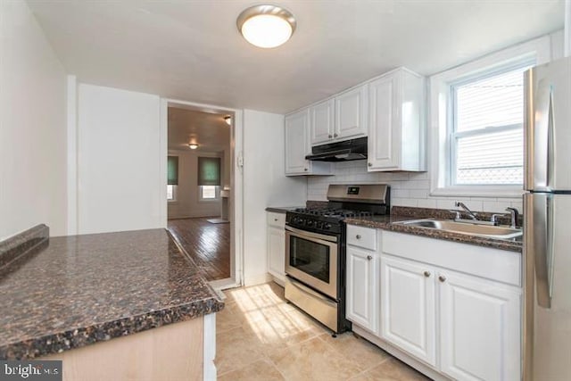 kitchen featuring backsplash, sink, appliances with stainless steel finishes, light hardwood / wood-style floors, and white cabinetry