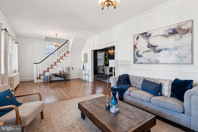 living room featuring hardwood / wood-style floors, a wealth of natural light, radiator, and an inviting chandelier