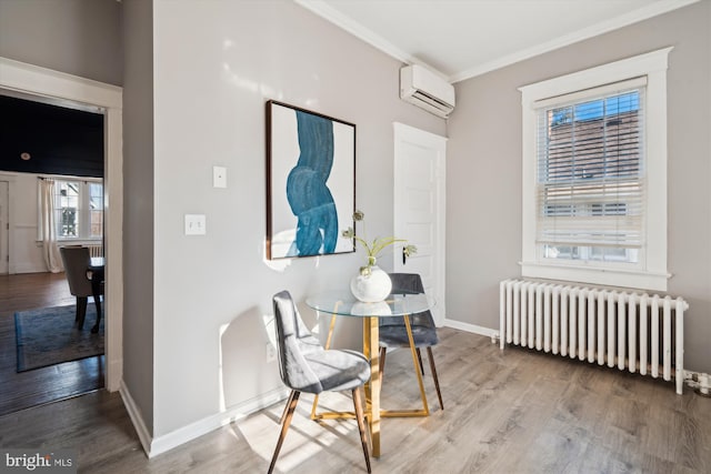 hall featuring radiator heating unit, light hardwood / wood-style flooring, a wall unit AC, and ornamental molding