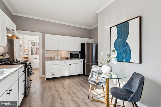 kitchen featuring ornamental molding, light wood-type flooring, tasteful backsplash, white cabinetry, and stainless steel appliances