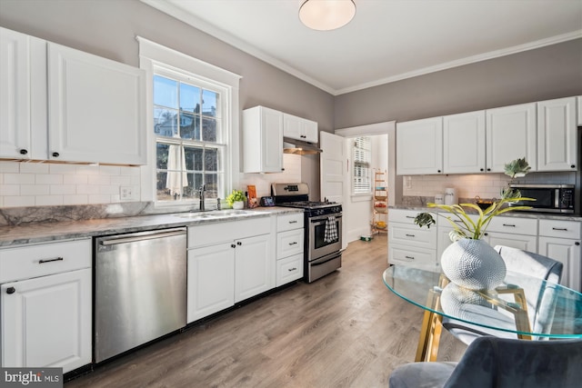 kitchen featuring decorative backsplash, sink, white cabinetry, and stainless steel appliances