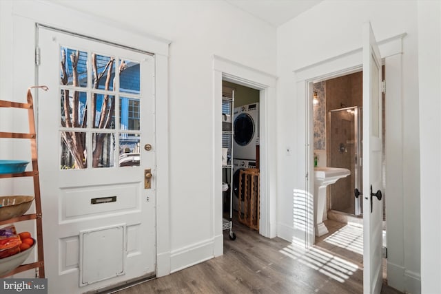 interior space with wood-type flooring and stacked washer / dryer