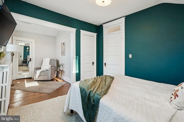 bedroom with hardwood / wood-style flooring and vaulted ceiling