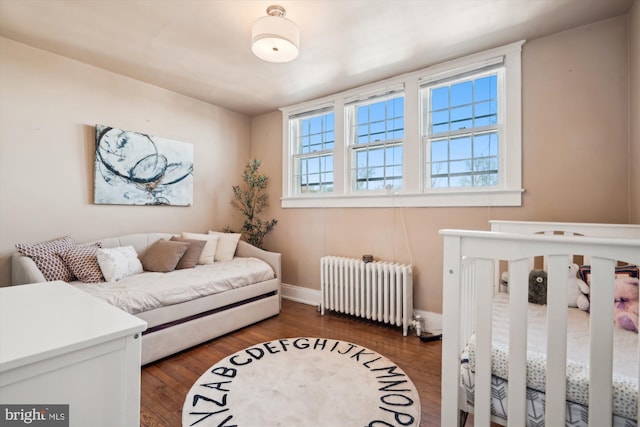 bedroom featuring dark hardwood / wood-style flooring and radiator heating unit