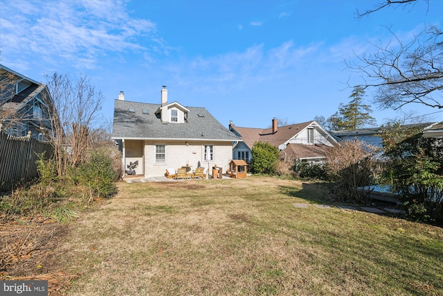 rear view of property featuring a lawn