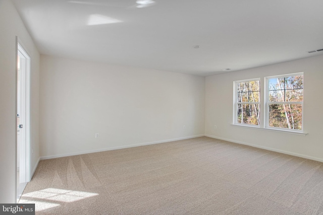 unfurnished room featuring light colored carpet