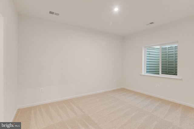 unfurnished room featuring light carpet