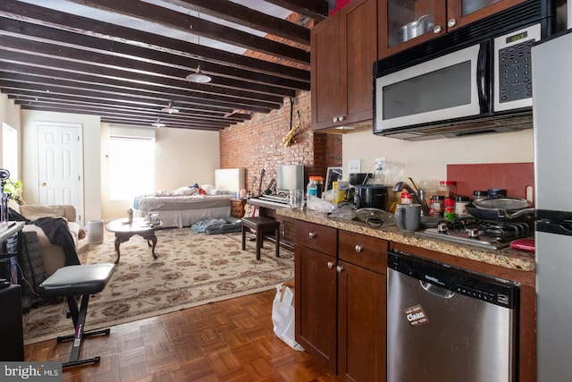 kitchen with brick wall, appliances with stainless steel finishes, a wall mounted AC, dark parquet flooring, and light stone counters