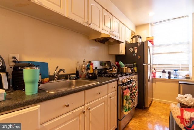 kitchen featuring white cabinetry, sink, light parquet floors, and stainless steel gas stove