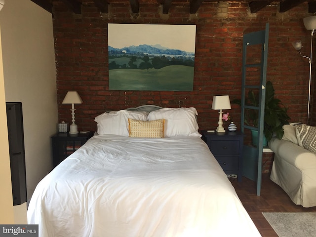 bedroom featuring dark parquet flooring and brick wall