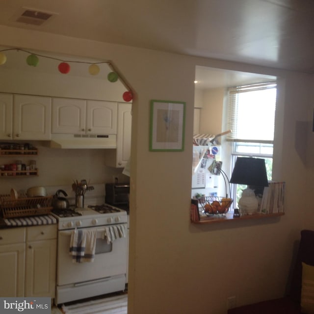 kitchen with gas range gas stove and white cabinets